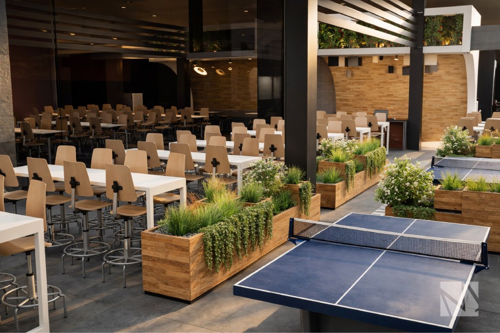 Employee social and recreation area with cafeteria seating and ping pong table at N1CO offices in Multiplaza San Salvador.