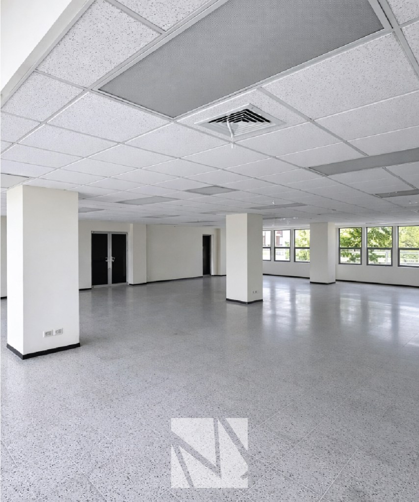 Espacio interior amplio de oficina en obra gris lista para adecuación, representando desarrollo y gestión de inmuebles corporativos por Modulare